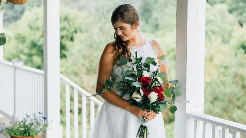 Bride standing on a balcony overlooking the picturesque wedding venue, moments before the ceremony begins.