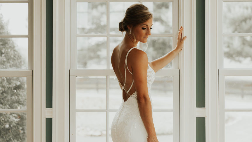 Bride poised gracefully in a doorframe, symbolizing the entryway to a new chapter in Loudoun County's elegant venues.