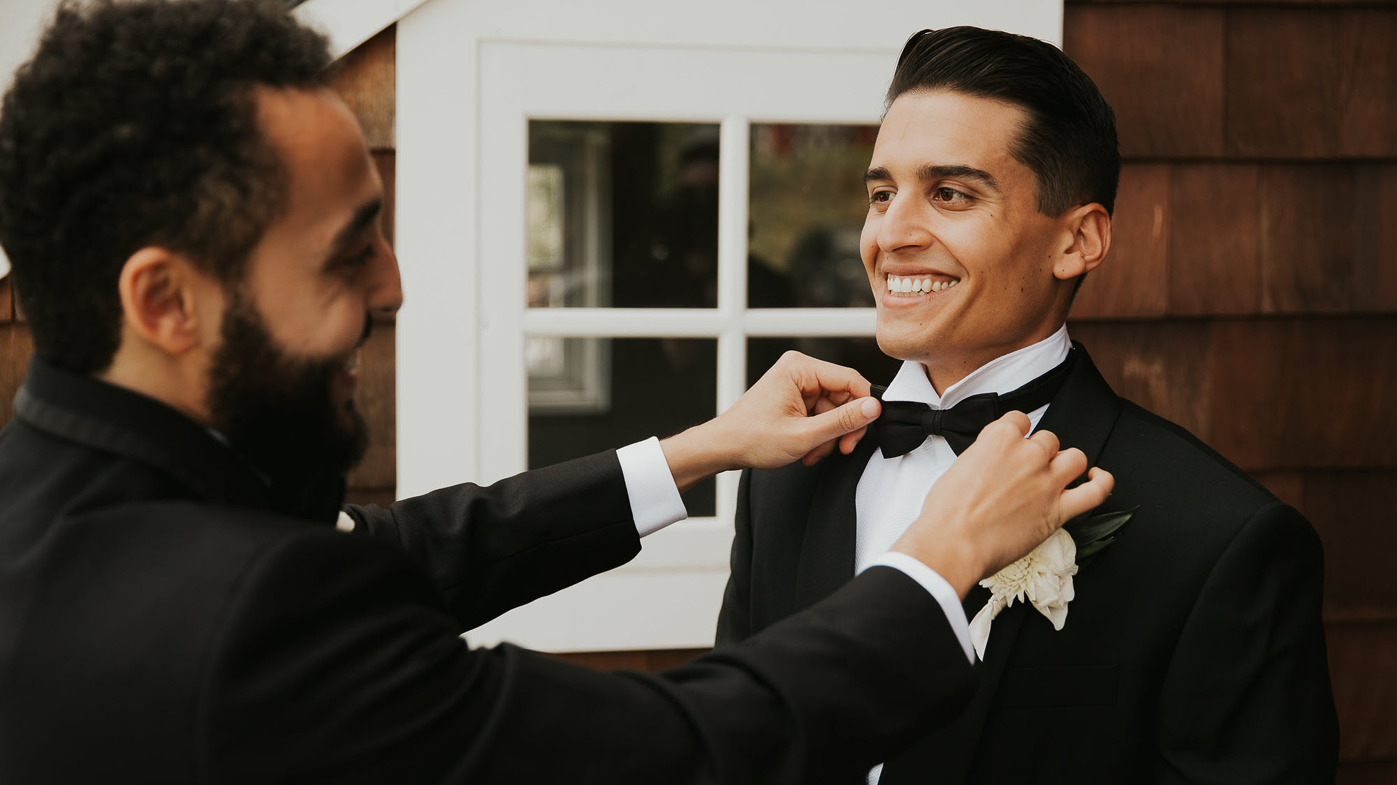 Groom's bowtie adjustment in a joyful pre-wedding ceremony moment at Zion Springs venue.