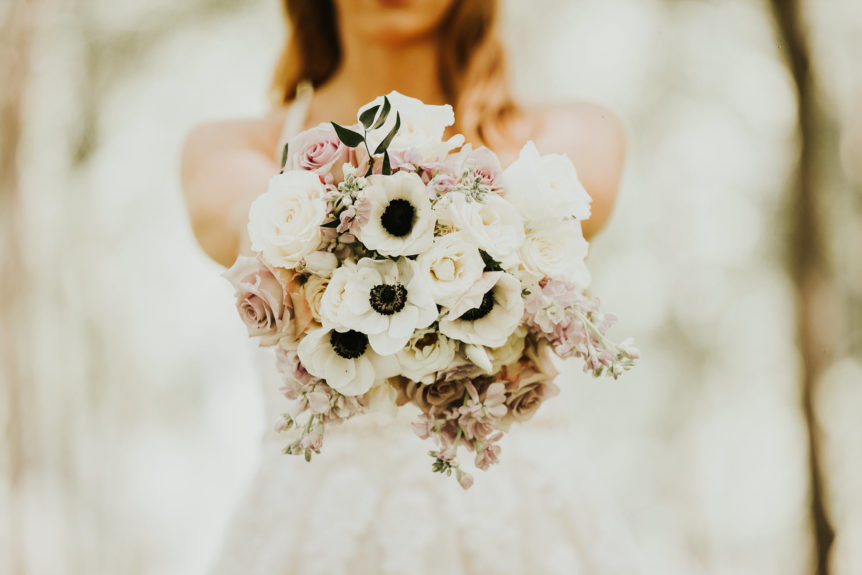 Summer bride holding a vibrant wedding bouquet
