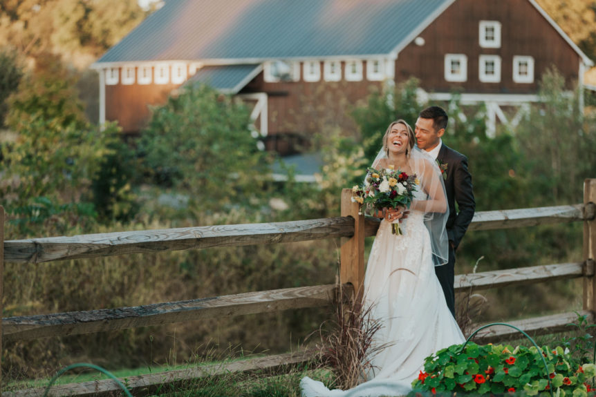 Newlyweds sharing a romantic moment by the barn at Zion Springs, a scenic wedding venue in Virginia.