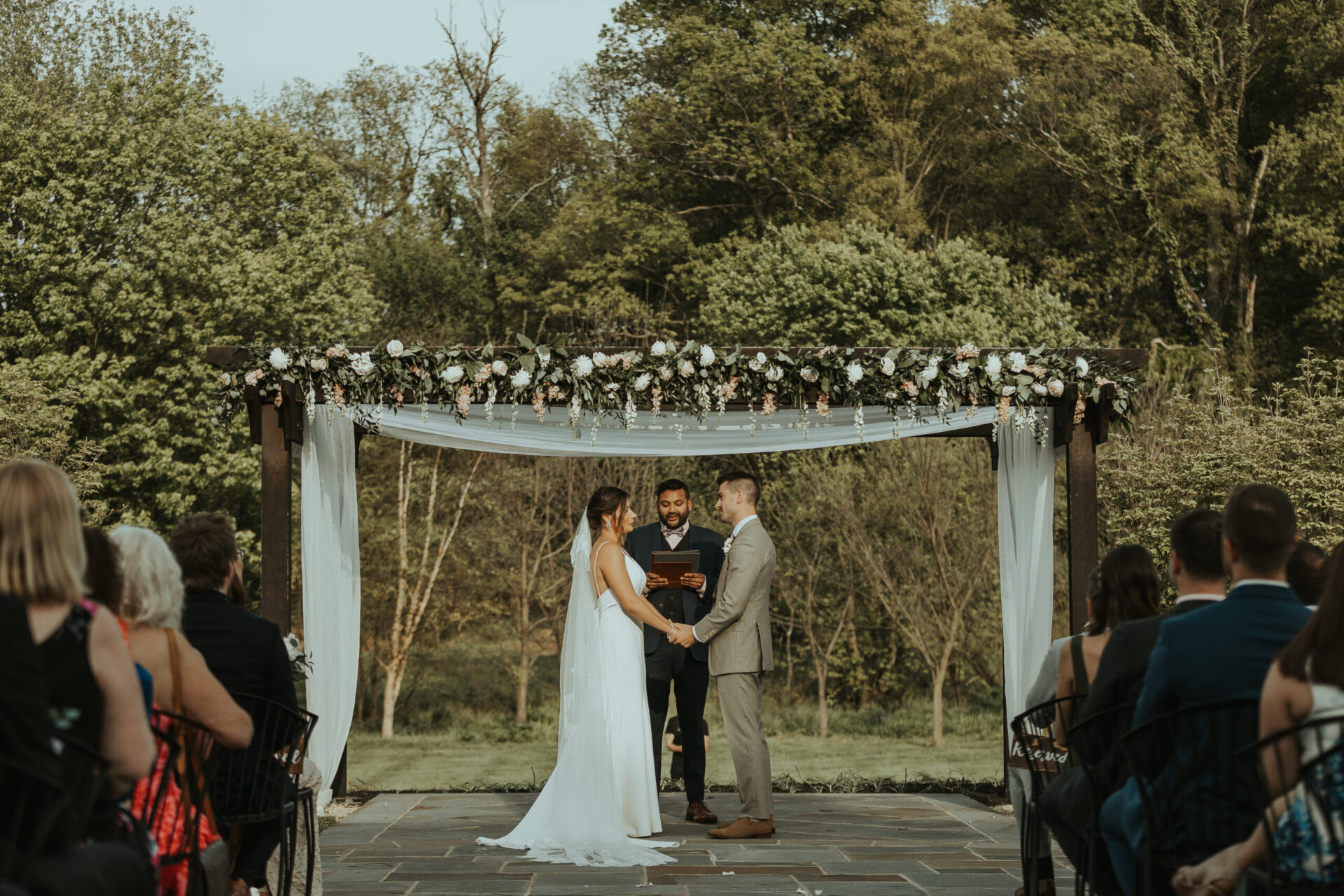 Zion Springs Real Wedding bride and groom standing under pergola covered in flowers