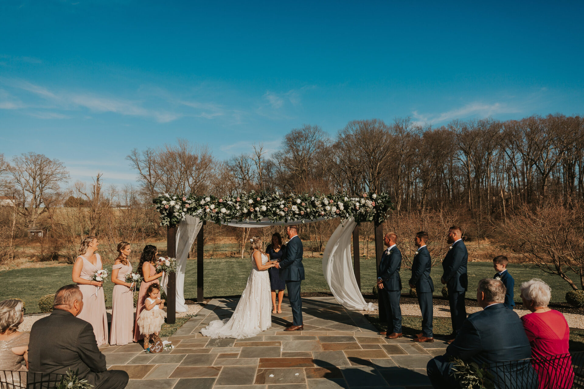 Zion Springs wedding ceremony with wedding party blule skies flower-strewn pergola
