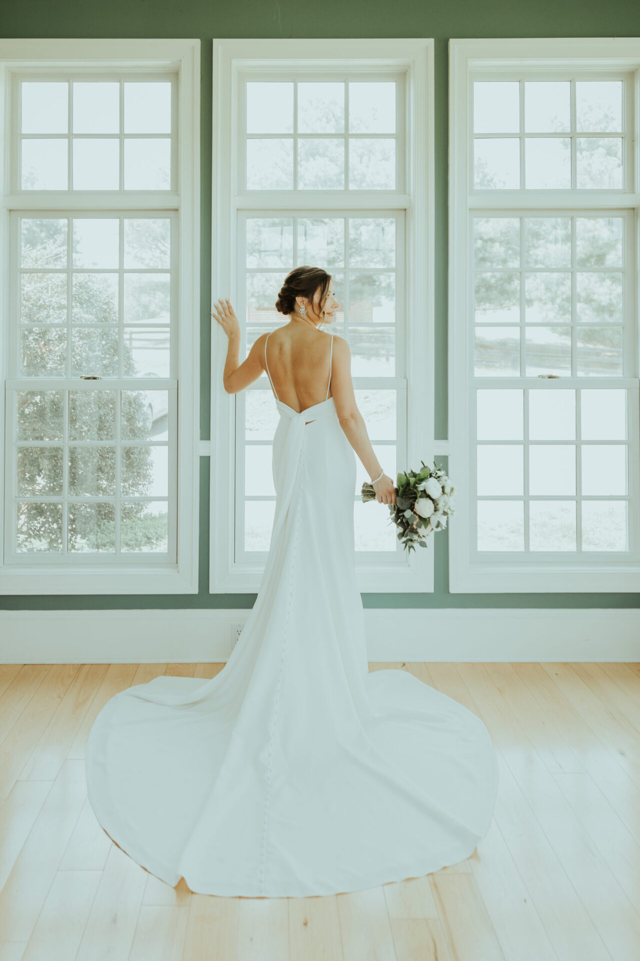 Zion Springs Real Wedding bride posing by white windows in The Music Room