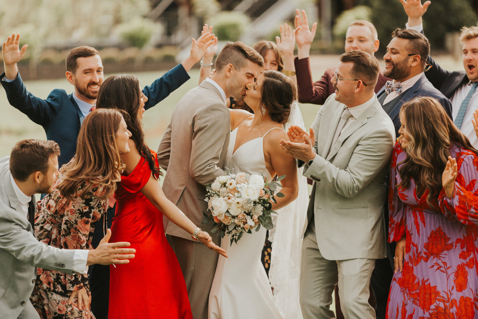 Zion Springs Real Wedding bride and groom kissing with bridesmaids and groomsmen chearing on