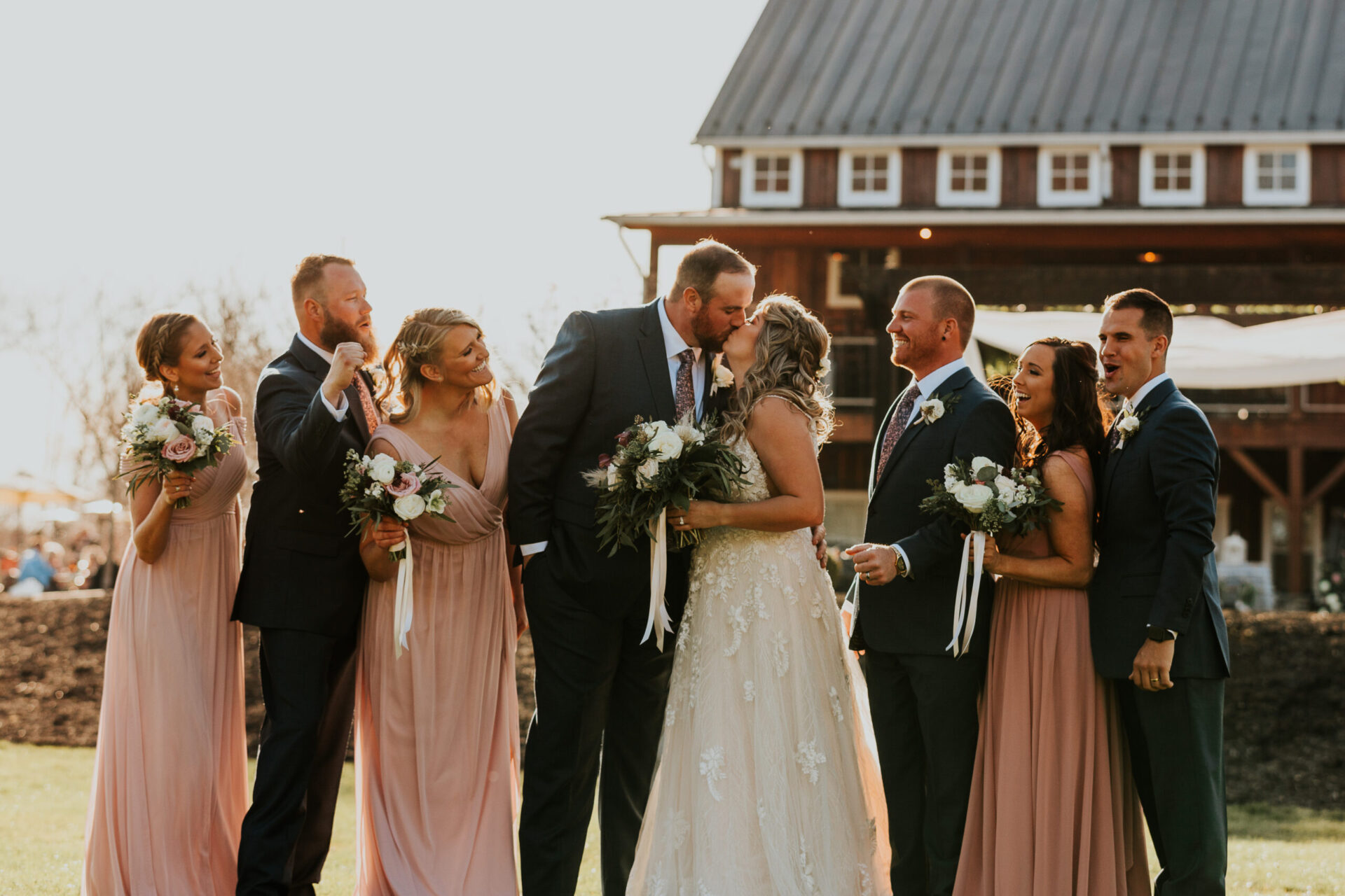 Zion Springs bride groom kissing surrounded by bridesmaids and groomsmen