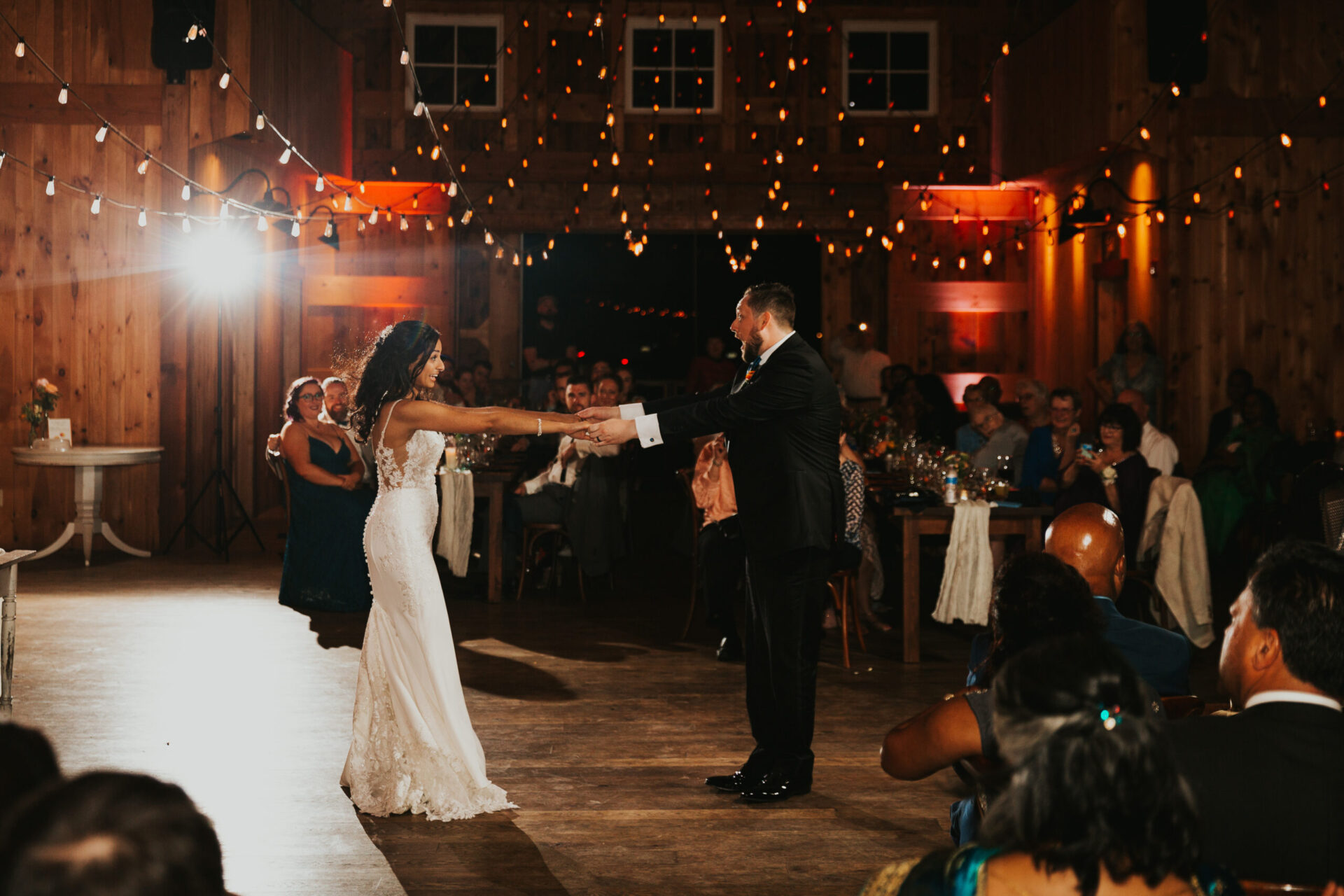 bride and groom dancing in rustic barn