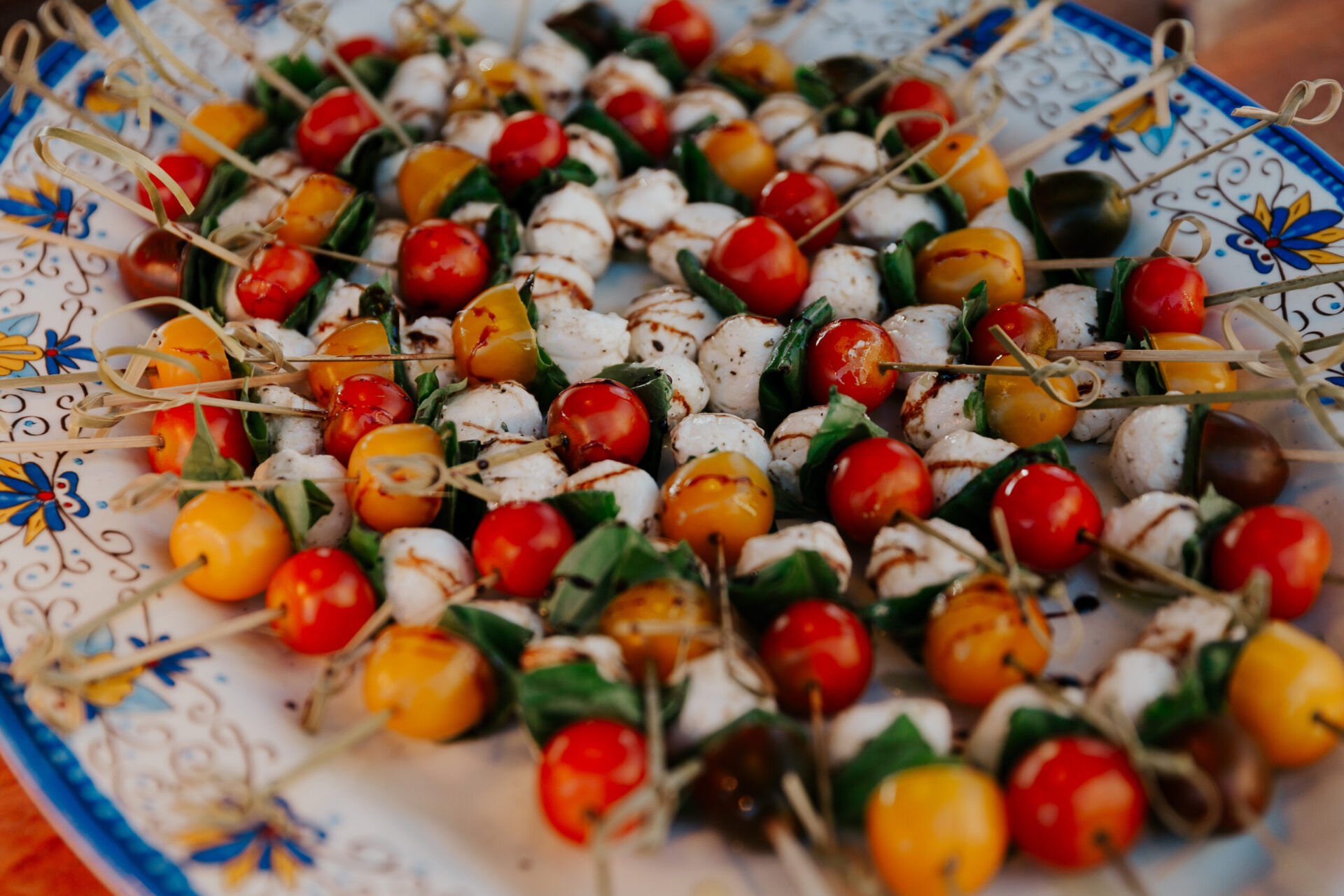 brightly colored grape tomatoes, caprese salad skewers on Italian platter