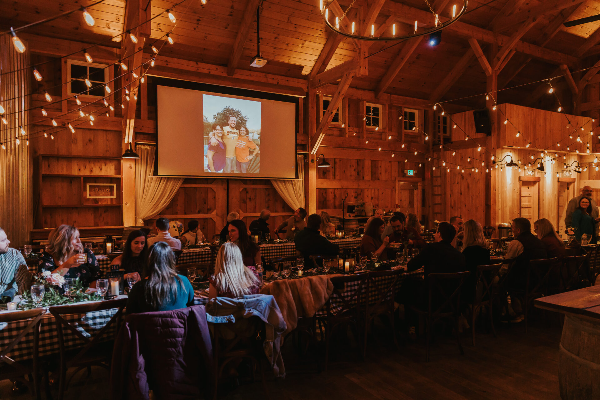 rehearsal dinner showing Thank You video in rustic barn
