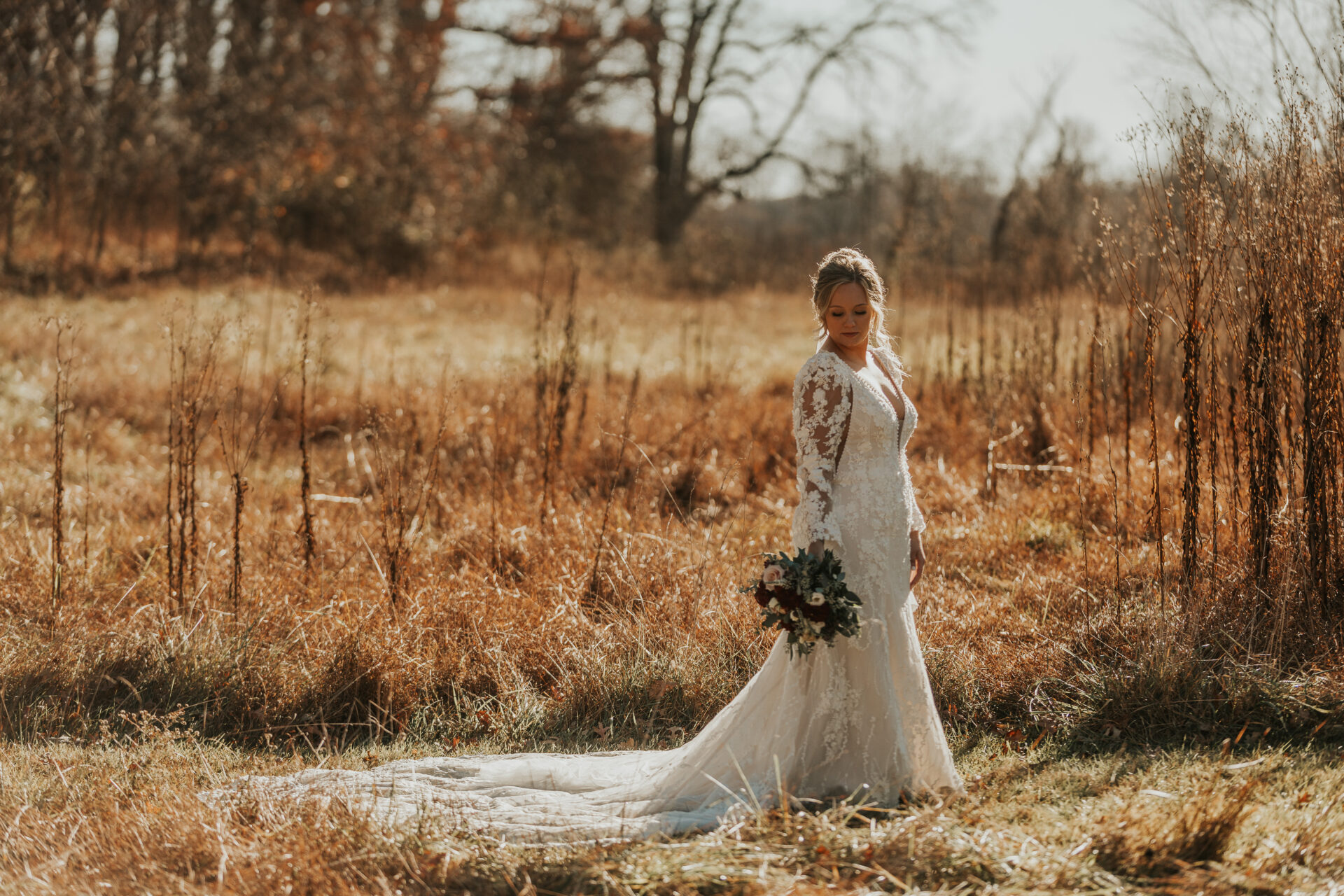 bride standing in meadow in early winter