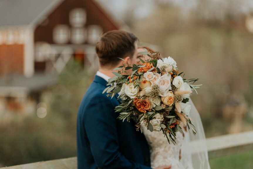 Newlyweds sharing a romantic moment by the barn at Zion Springs, a scenic wedding venue in Northern Virginia.