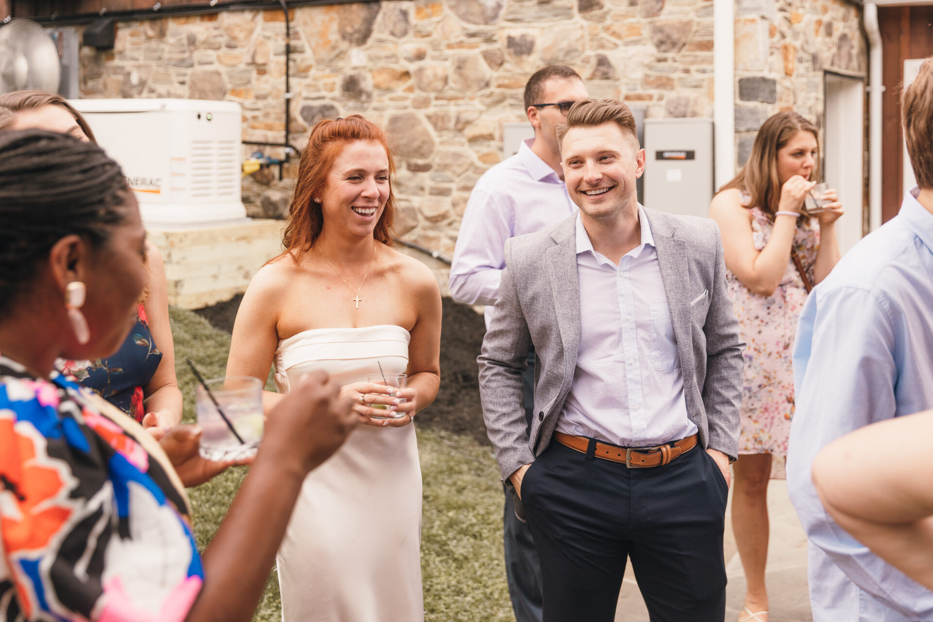 cocktail hour at rustic barn venue with couples mingling