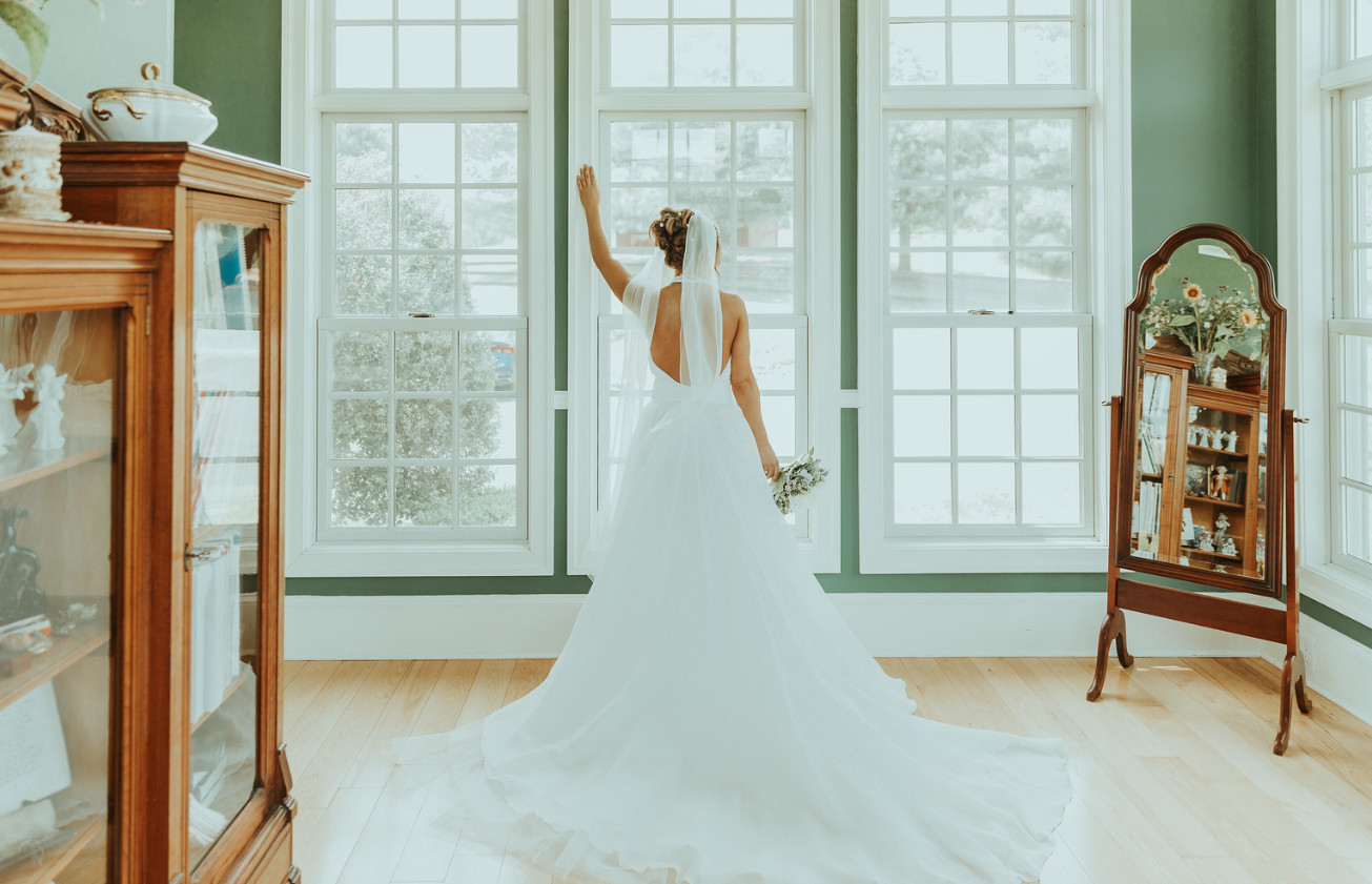 back view of a bride looking out the window in Zion Springs music room