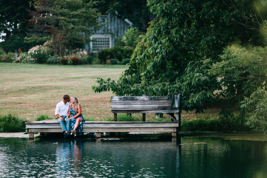 couple sittin on pier next to lake