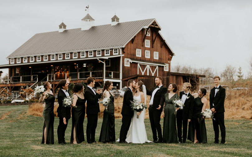 brides and bridesmaid with wedding couple in front of Zion Springs rustic barn