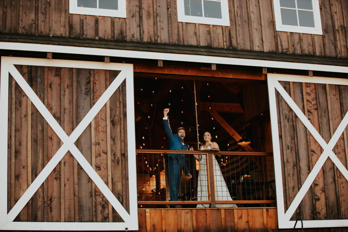 Bride, groom, ringing the bell, rustic barn