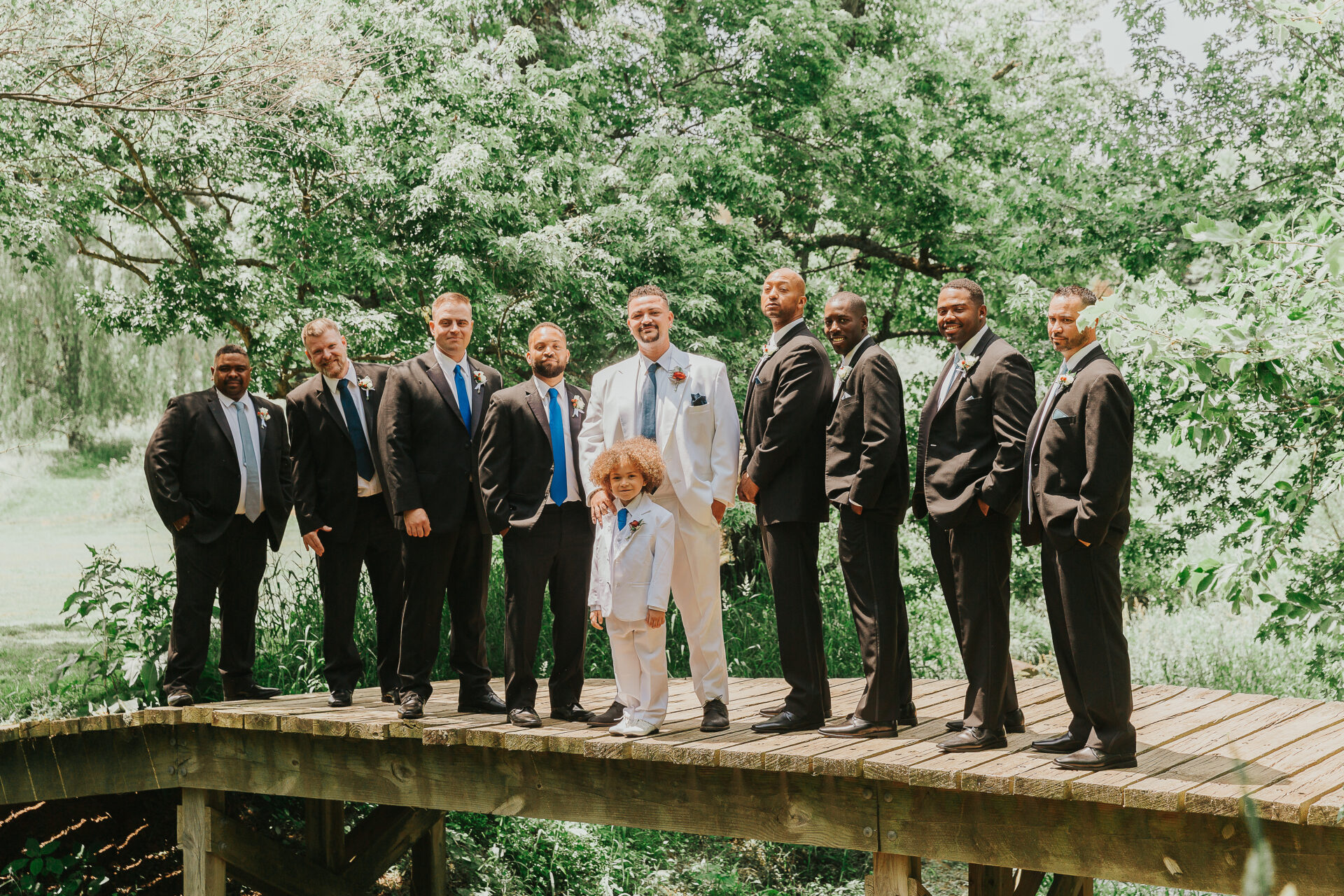 groom and groomsmen standing on the bridge