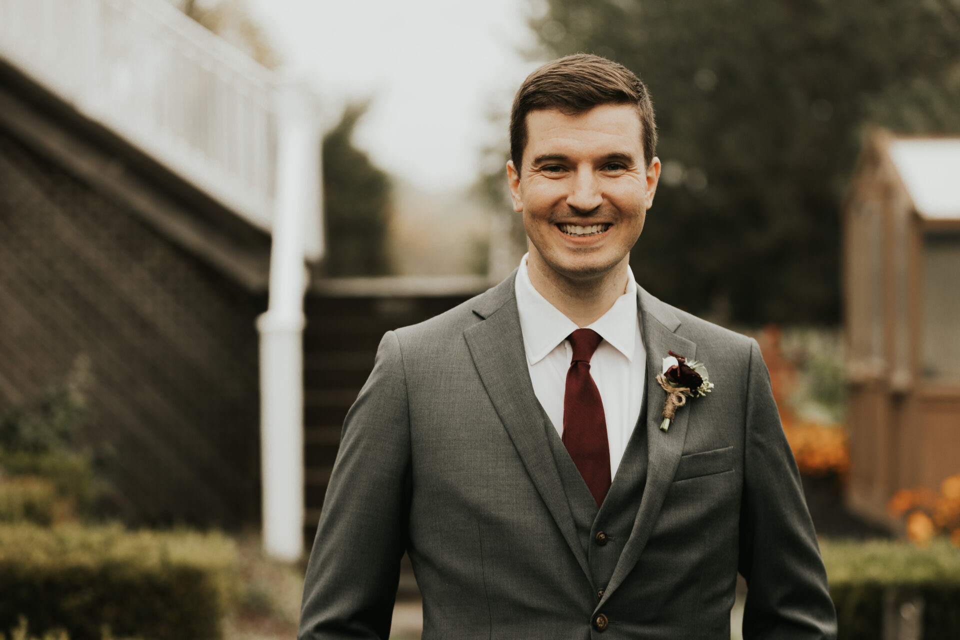 groom, burgundy tie, steps, manor house, fall wedding, rustic barn