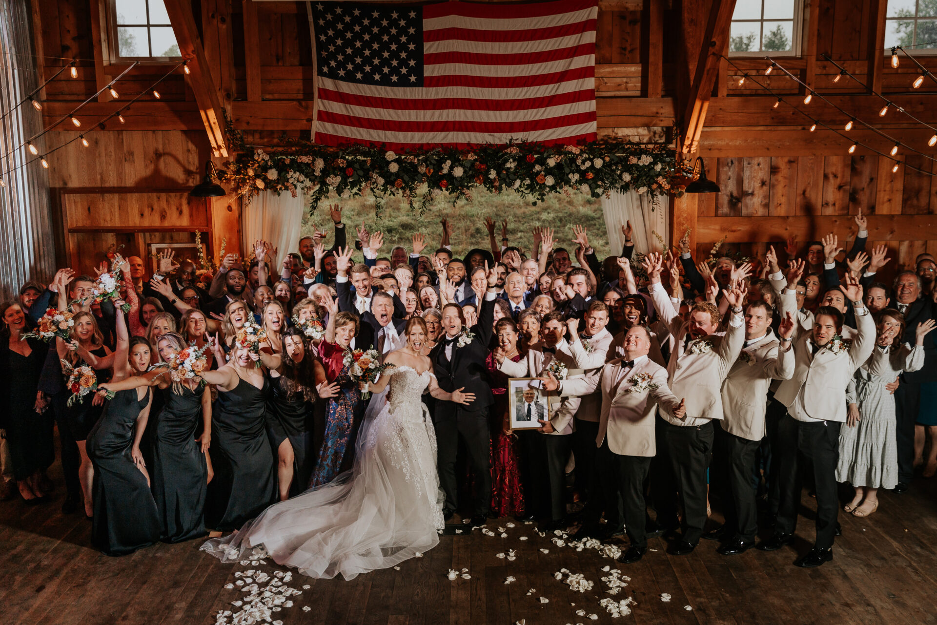 wedding party, bride, groom, family, friends, rustic barn, American flag