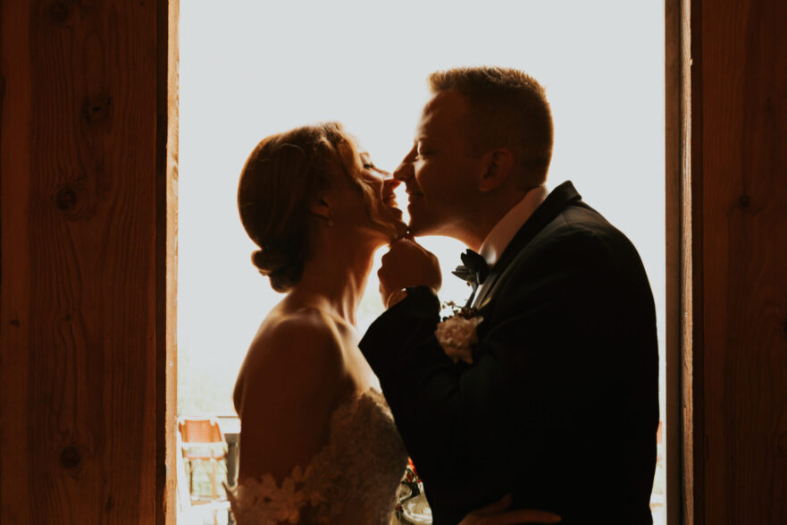 bride groom silhouette kissing rustic barn