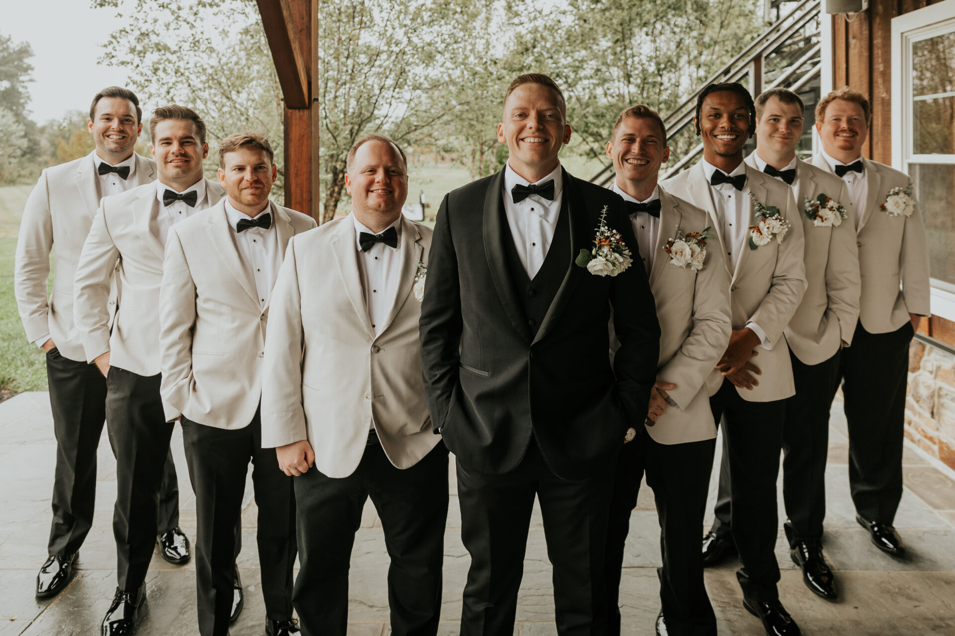 Groom, groomsmen, rustic barn, white suit, black tie