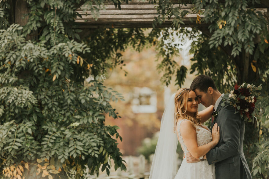 bride, groom, bridal bouquet, pergola, rustic wedding barn, first kiss