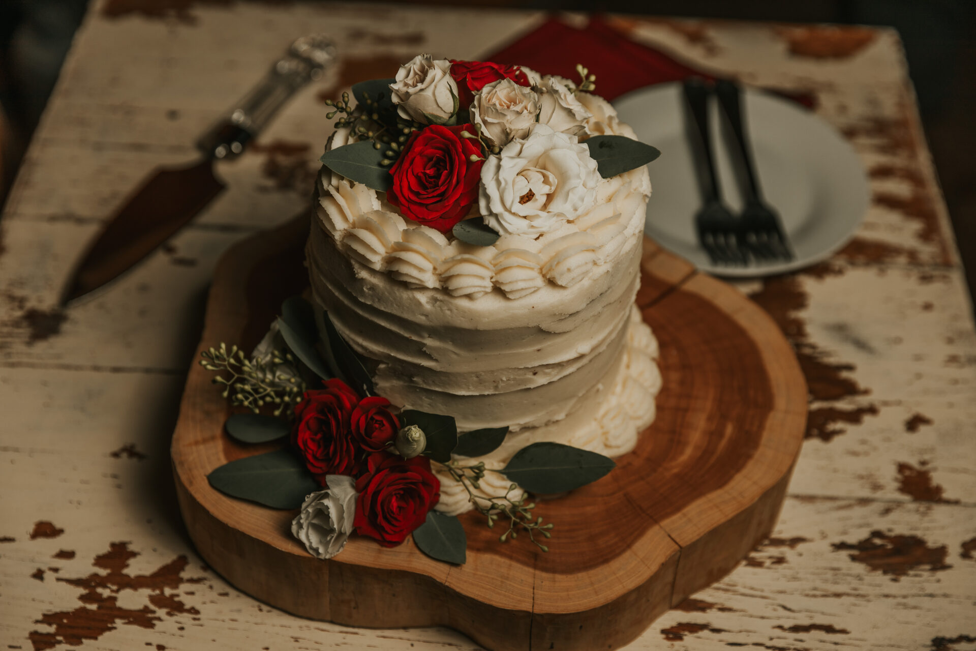 wedding cake, white frosting, red roses, white roses, wood platter