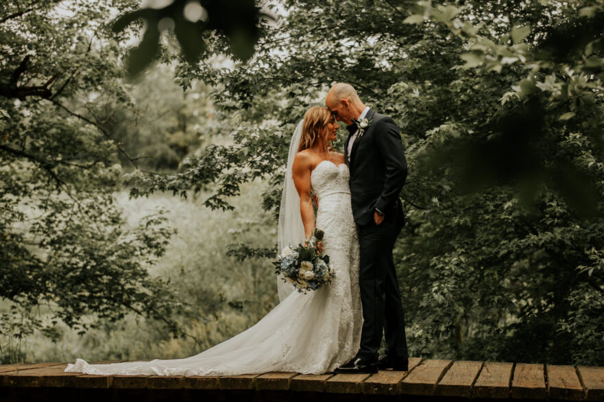 Newlyweds share a romantic moment in the beautiful grounds at Zion Springs, an indoor-outdoor barn wedding venue, in Northern Virginia.