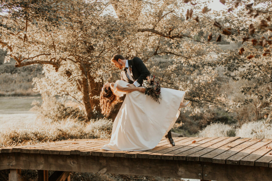 Newlyweds sharing a romantic moment on the bridge at Zion Springs, an all-inclusive scenic wedding venue in Northern Virginia.