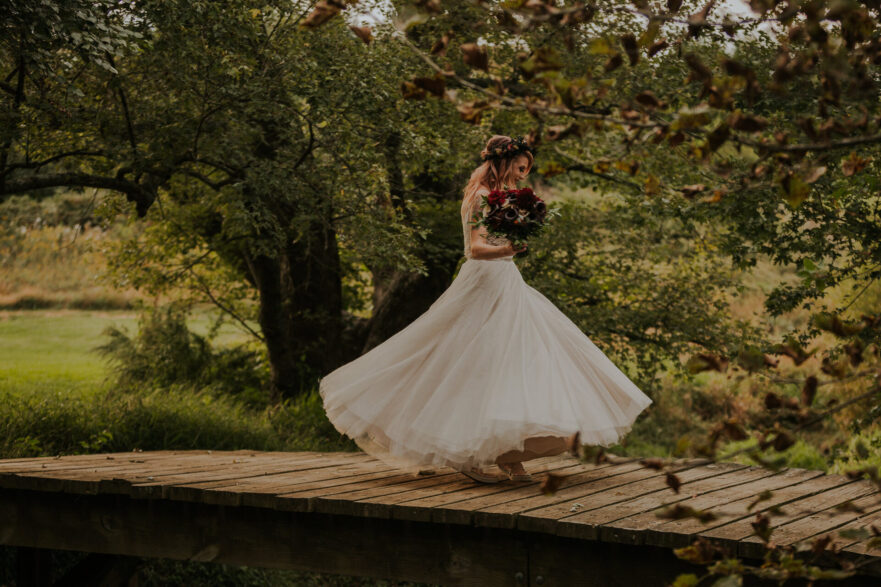 Bride on a rustic wooden bridge at Zion Springs, a Northern Virginia wedding venue – tips for planning a rustic-themed wedding.