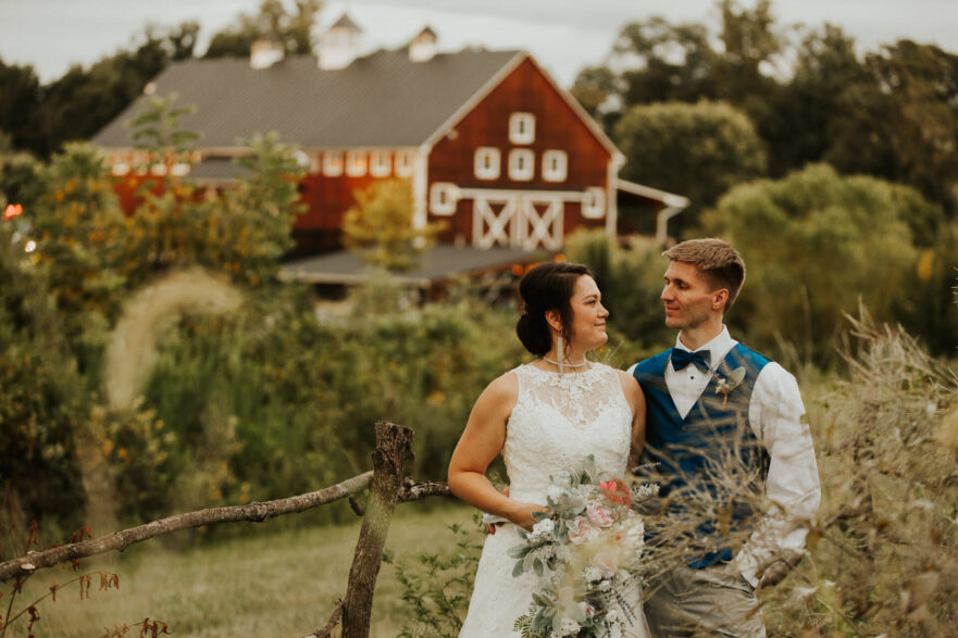 Newlyweds sharing a romantic moment by the barn at Zion Springs, a scenic wedding venue in Northern Virginia.