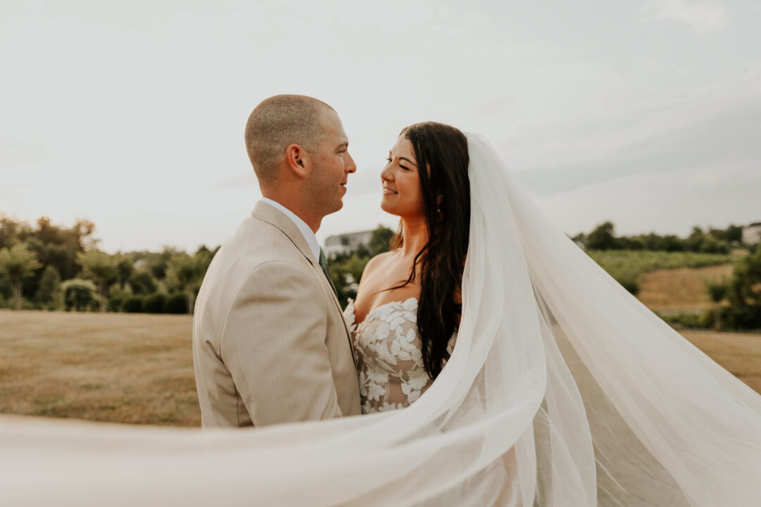 Newlyweds smiling at Zion Springs with flowing veil and scenic outdoor backdrop.